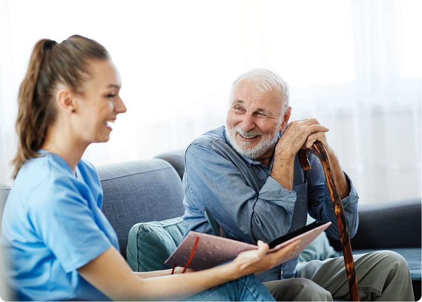 Home healthcare worker speaking with an older patient in a comfortable living room, illustrating the rise of personalised care in the silver economy.